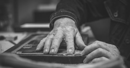aged hand sanding wood, representing restoration