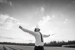 Thankful Businessman with Open Arms at the Field, abundant living concept