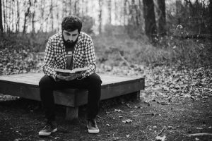 man reading his bible in woods, restoration scriptures concept