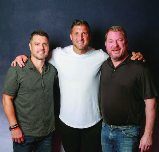 Redeemed director Nathan Dewberry (L) and founder Paul Amos (R) with Tebow at Restored ‘23