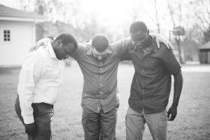 group of diverse friends with hands on shoulders, spiritual battle against community concept