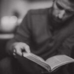 man reading his Bible, black and white blurred image