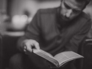 man reading his Bible, black and white blurred image